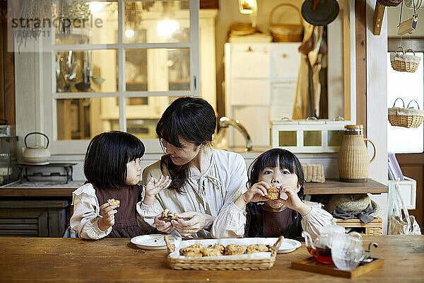 Japanisches Elternteil und Kind beim Snacken
