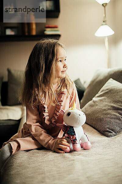 Schönes kleines Mädchen mit ihrem Spielzeug zu Hause.