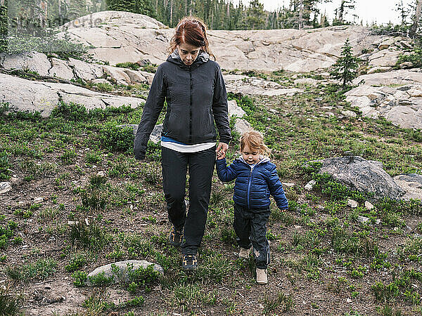 Mutter und Tochter wandern von Felsen hinunter  Colorado