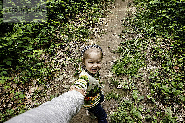 Mädchen zieht Mutter im Wald auf einer Wanderung