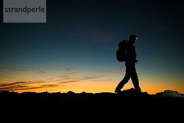 Backpacker-Wandergrat bei Nacht mit Stirnlampe.