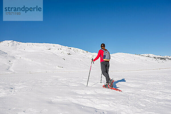 Frau übt Wintersport aus. Schneeschuhwandern an einem sonnigen Tag