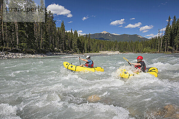 Two men packrafting through white water  Kootney National Park.