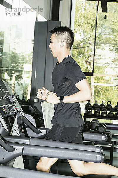 Mann läuft auf dem Laufband im Fitnessstudio in Bangkok