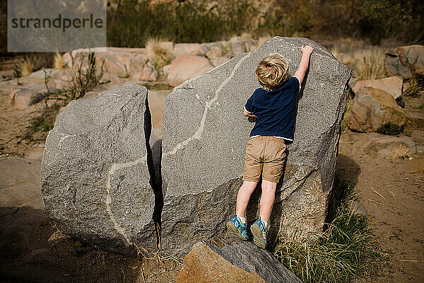 Dreijähriger Junge spielt auf Felsen bei Mission Trails in San Diego