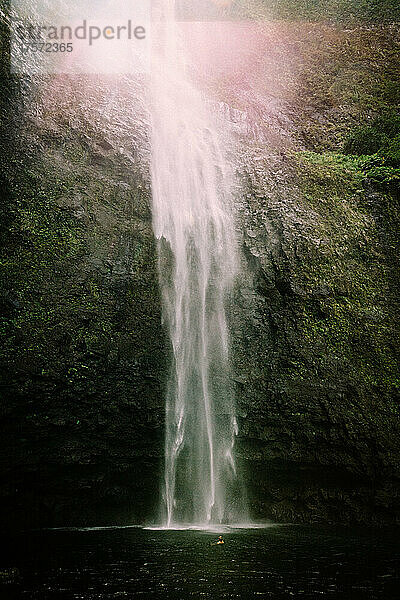 Winzige Figur blickt vom Fuß der Hanakapi'ai-Wasserfälle auf. f