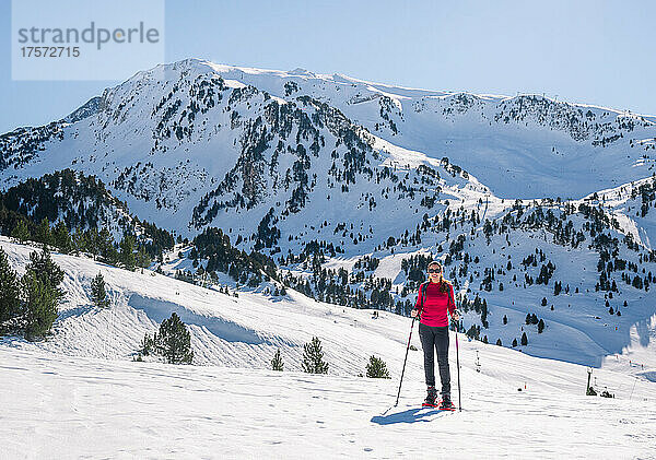 Frau übt Wintersport aus. Schneeschuhwandern an einem sonnigen Tag
