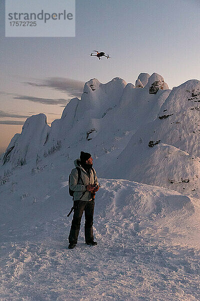 Drohnenpilot startet eine Drohne in gefrorener Landschaft