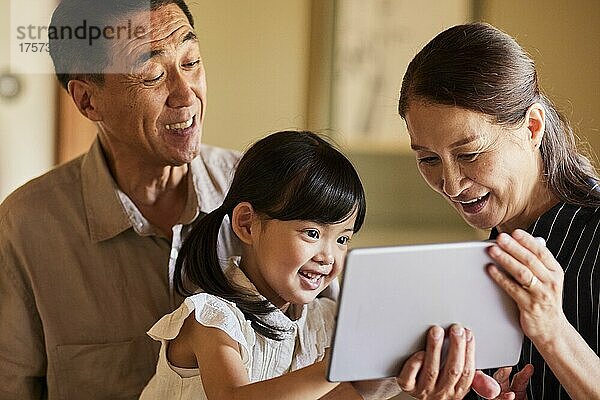 Japanische Großeltern und Enkelkinder nutzen Tablet-Geräte