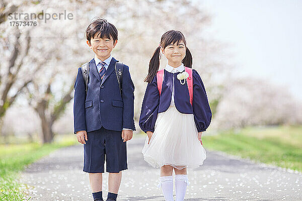 Japanische Grundschüler mit unter den Kirschblüten