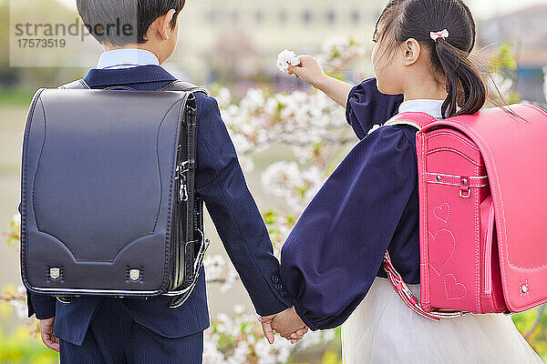 Japanische Grundschüler halten sich an den Händen