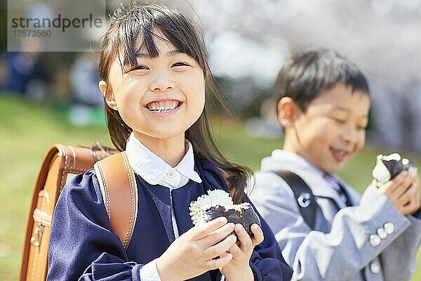 Japanische Grundschüler essen Reisbällchen