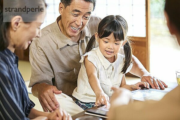 Lächelnder Enkel und japanisches Seniorenpaar