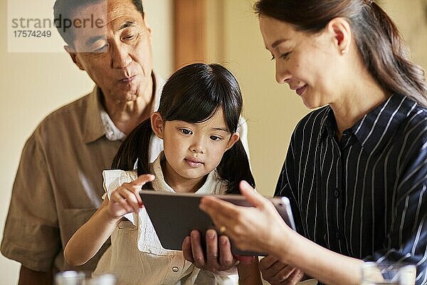 Japanische Großeltern und Enkelkinder nutzen Tablet-Geräte