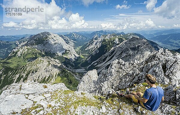 Wanderer sitzt am Gipfel der Lamsenspitze  Ausblick in das Falthurntal mit Gipfel Sonnjoch und Rappenspitze  Karwendelgebirge  Alpenpark Karwendel  Tirol  Österreich  Europa