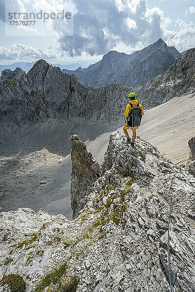 Wanderer auf Felsvorsprung  Wanderweg zur Lamsenspitze  hinten Kar und felsige Berggipfel mit Mitterkarlspitze  Karwendelgebirge  Alpenpark Karwendel  Tirol  Österreich  Europa