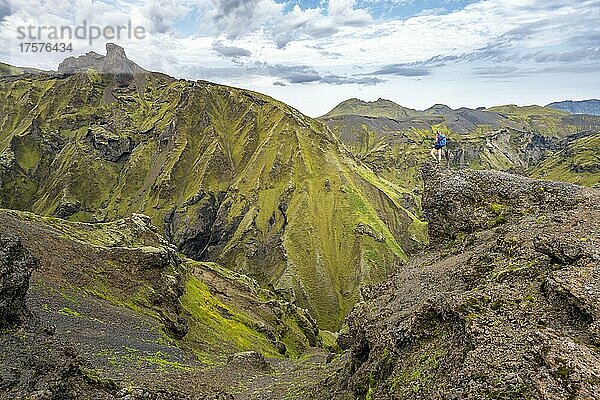 Wanderin blickt über spektakuläre Landschaft  mit Moos bewachsene Klippen  Pakgil  Island  Europa