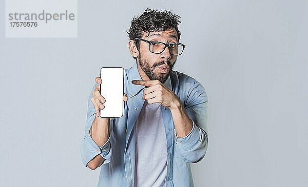 Junger Mann zeigt leeren Handy-Bildschirm  Mann zeigt und deutet auf seinen Handy-Bildschirm