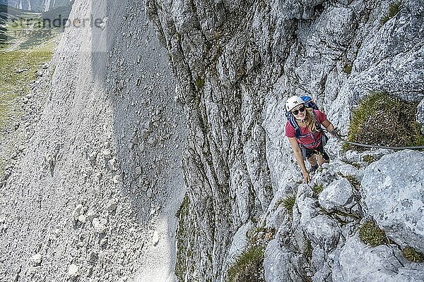 Junge Frau klettert an einer steilen Felswand  Lamsenspitze Klettersteig  Tirol  Österreich  Europa