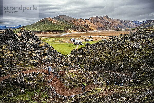Wanderer auf einem Wanderweg  hinten Landmannalaugar Camp  Berge von Landmannalaugar  Suðurland  Südisland  Island  Europa