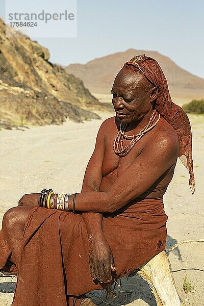 Himba-Frau  die sich am Ufer des trockenen Flussbettes des Hoarusib-Flusses ausruht  Kaokoland  Kunene-Region  Namibia  Afrika