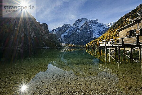 Bootshaus mit Sonne und Croda del Becco  Seekofel  Spiegelung im See im Herbst  Pragser Wildsee  Provinz Bozen  Südtirol  Dolomiten  Italien  Europa