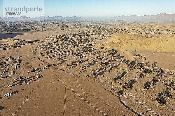 Das trockene Bett des Aba-Huab-Flusses kurz vor seinem Zusammenfluss mit dem Huab-Fluss  links die abgelegene Siedlung De Riet  Luftaufnahme  Drohnenaufnahme  Damaraland  Kunene-Region  Namibia  Afrika