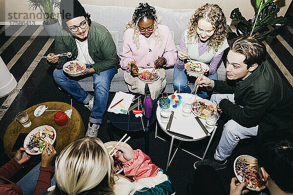 Hoher Blickwinkel auf männliche und weibliche Studenten verschiedener Rassen  die im Studentenwohnheim Essen genießen