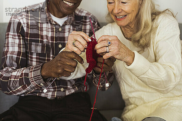 Älterer Mann und Frau stricken gemeinsam im Altersheim