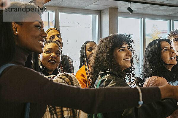 Lächelnde multirassische Studenten  die gemeinsam ihre Testergebnisse an der Universität überprüfen