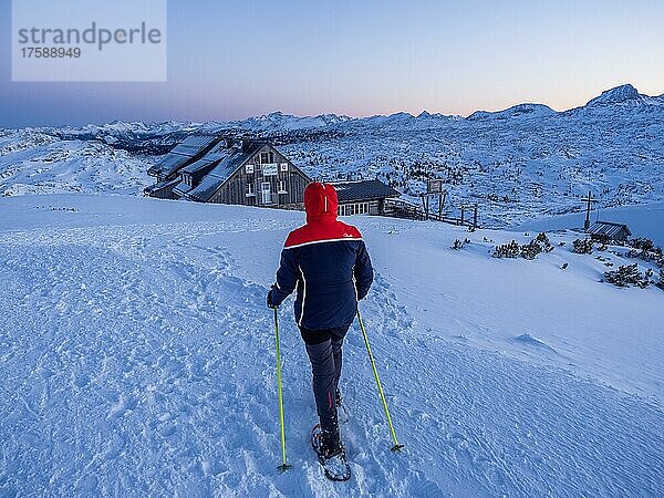 Schneeschuhwanderin auf dem Weg zur Krippenstein Lodge  Abendstimmung in verschneiter Winterlandschaft  Krippenstein  Salzkammergut  Oberösterreich  Österreich  Europa