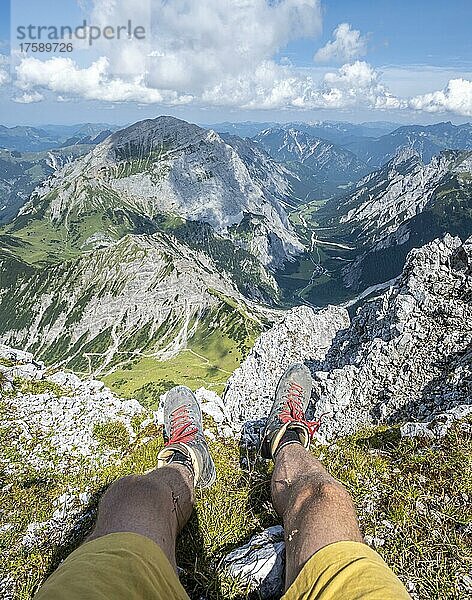 Berglandschaft  Wanderer lässt Beine baumeln  Wanderschuhe und Ausblick von der Lamsenspitze auf Berge und das Gramaital  Karwendelgebirge  Tirol  Österreich  Europa