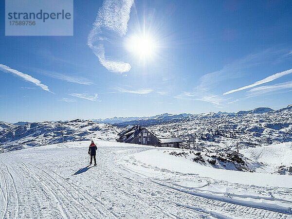 Schneeschuhwanderin in Winterlandschaft im Hochgebirge  hinten Krippenstein Lodge und verschneite Alpengipfel  Krippenstein  Salzkammergut  Oberösterreich  Österreich  Europa