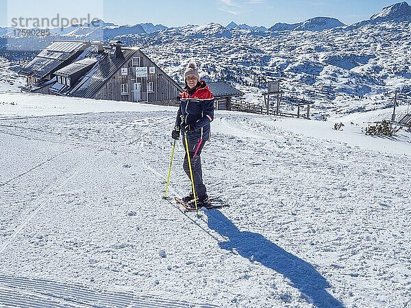 Blauer Himmel über Schneeschuhwanderin in Winterlandschaft  verschneite Berggipfel  Aussicht auf die Krippenstein Lodge  Salzkammergut  Oberösterreich  Österreich  Europa