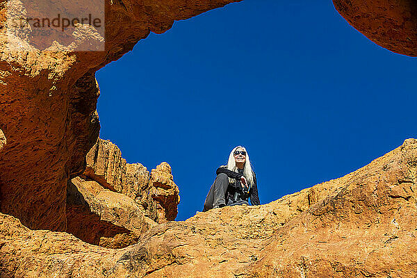 Vereinigte Staaten  Utah  Bryce-Canyon-Nationalpark  Senior-Wanderer sitzt auf einem Sandsteinvorsprung