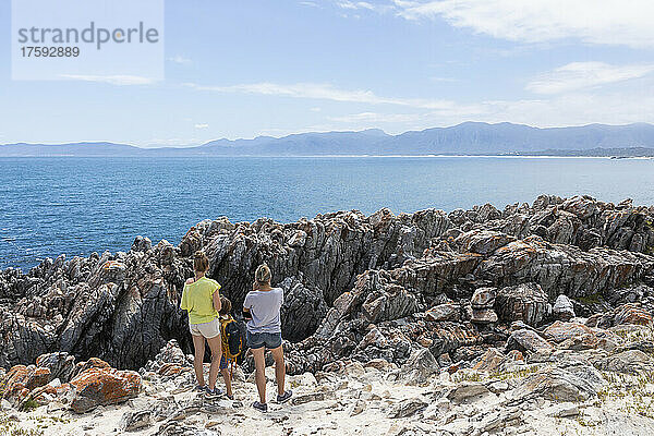 Südafrika  De Kelders  Frau mit Mädchen (16-17) und Junge (8-9) beim Wandern an der Atlantikküste