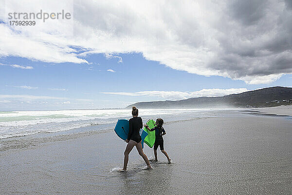 Südafrika  Hermanus  Mädchen (16-17) und Junge (8-9) mit Bodyboards am Grotto Beach