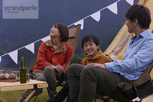 Japanische Familie unterhält sich auf dem Campingplatz