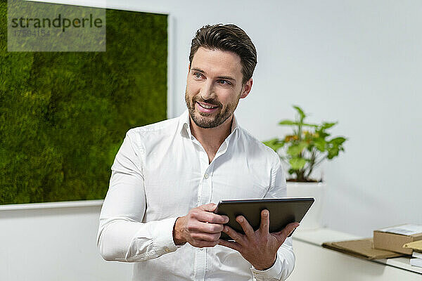 Nachdenklicher Geschäftsmann mit Tablet-PC im Büro