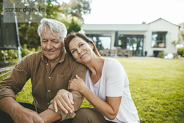 Lächelnder Mann und Frau sitzen zusammen im Hinterhof