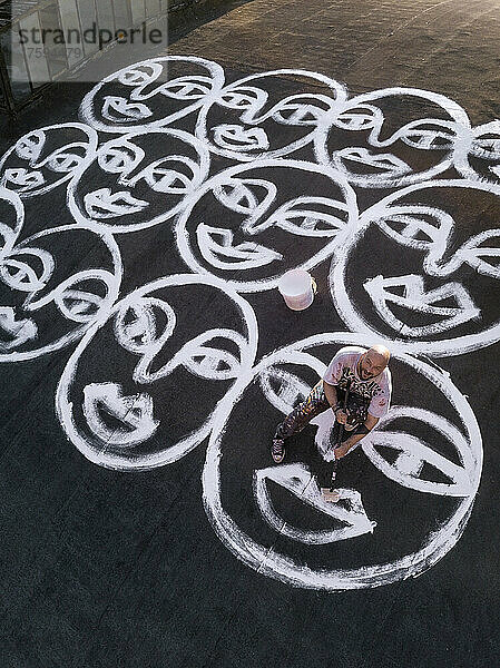 Artist painting smiley faces on roof