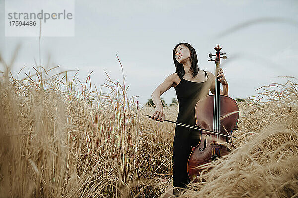 Woman playing cello in field
