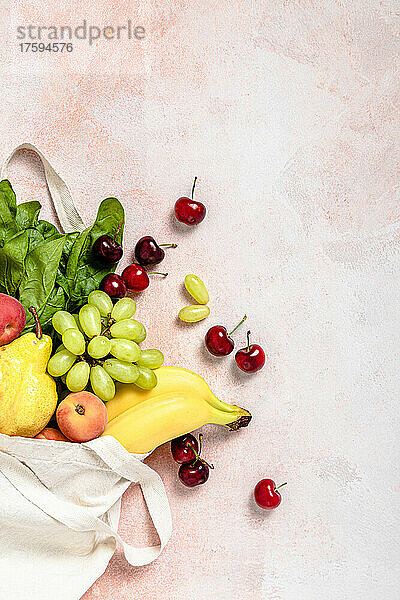 Studioaufnahme einer wiederverwendbaren Tasche  gefüllt mit reifem Obst und Gemüse