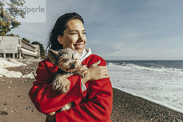 Glückliche Frau mit Hund am Strand