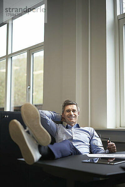 Smiling businessman relaxing in office