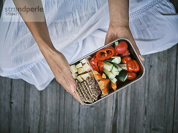 Woman sitting with lunch box