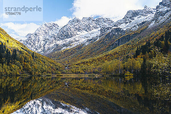 Schneebedeckte Berge  die sich im Herbst über den See spiegeln  Naturschutzgebiet Kaukasus  Sotschi  Russland