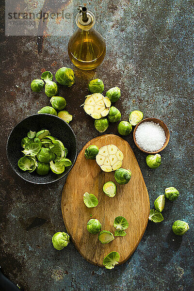 Bottle of olive oil and halved Brussels sprouts on cutting board