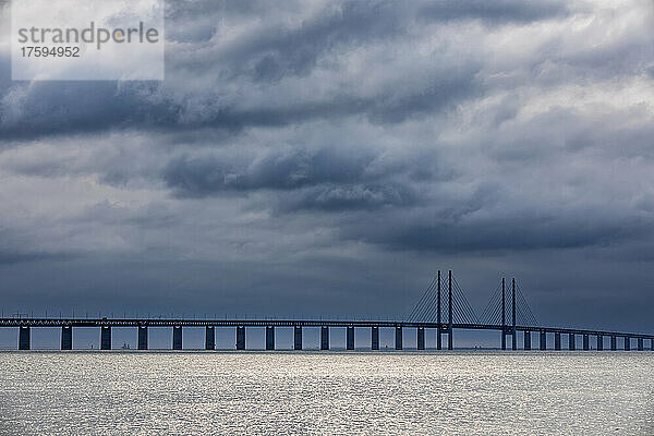 Bewölkter Himmel über der Meerenge mit der Silhouette der Öresundbrücke im Hintergrund