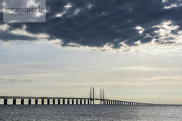 Dunkle Wolken über der Silhouette der Öresundbrücke in der Abenddämmerung